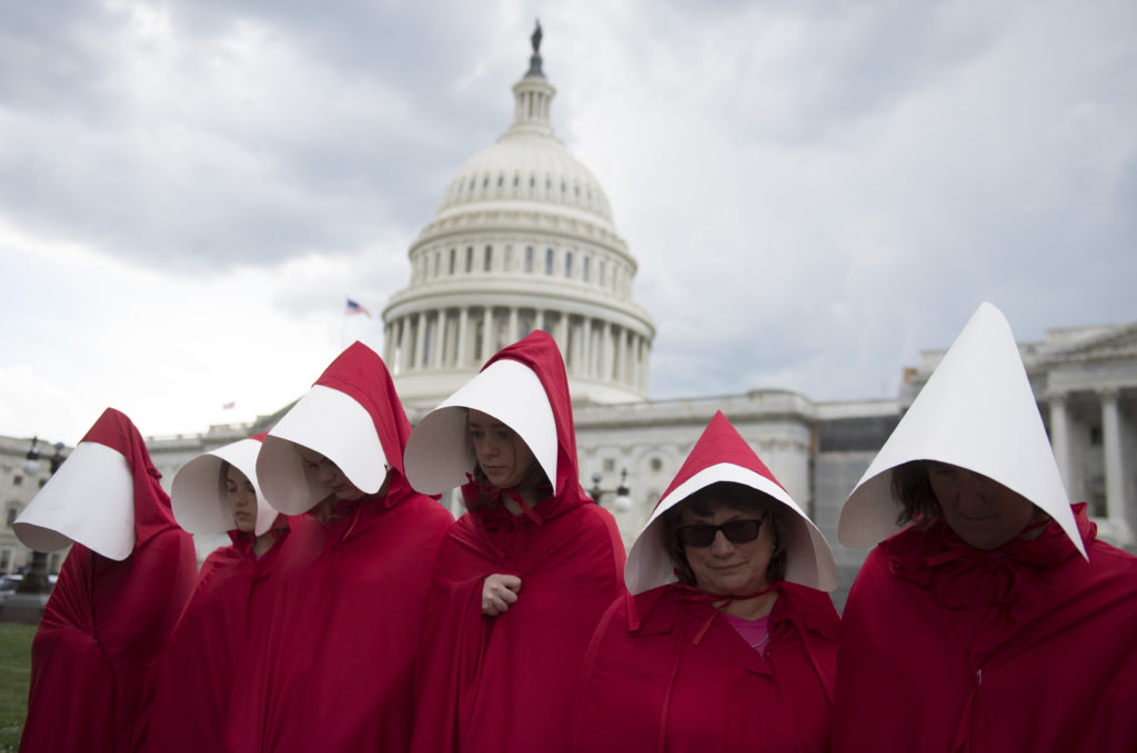 Supporters of Planned Parenthood dressed as characters from "The Handmaid's Tale," hold a rally as they protest the US Senate Republicans' healthcare bill outside the US Capitol in Washington, DC, June 27, 2017. ( Photo Credit: Should read SAUL LOEB/AFP/Getty Images)