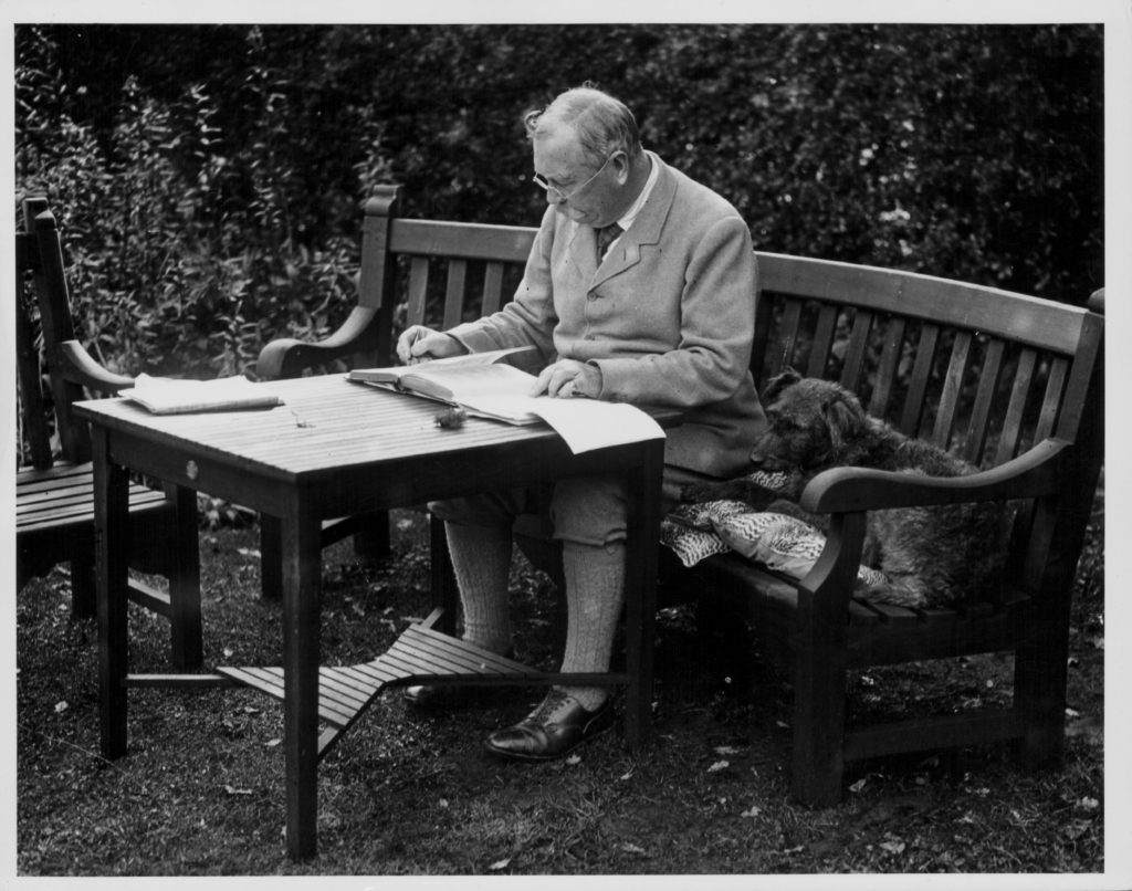 Portrait of Sir Arthur Conan Doyle sitting at a table in his garden, Bignell Wood, New Forest, 1927. (Photo by Fox Photos/Hulton Archive/Getty Images)